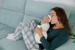 © Lucia PSV - A young woman is feeling very physically unwell. Her body is heavy, she feels very ill, very tired. Her head hurts, her throat hurts, she has a lot of mucus, a cough and a fever.
