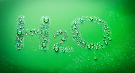 Poster - Water droplets on green surface with H2O writing creating a refreshing vibrant image of liquid and hydration