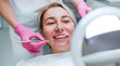 © Soloviova Liudmyla - Portrait of smiling female gazing at mirror in stomatology chair and graceful dentist's palms in pink gloves with excavator and mirror medical tools. Health care and medicare industry concept image