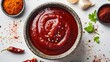 © fivan - A tangy Korean gochujang sauce in a traditional bowl surrounded by chili paste, garlic, and sesame oil