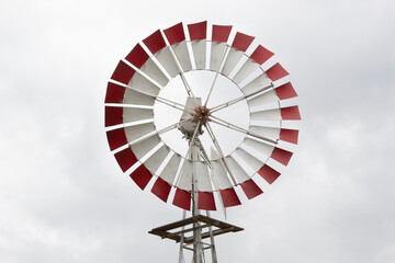 White and red windmill with grey sky at background