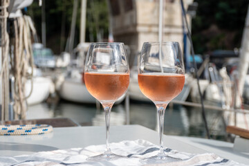 Party with rose wine on yacht boat anchored in port la Rague, Gulf of La Napoule, in Provence, two glasses of cold rose wine, French Riviera near Cannes, south of France