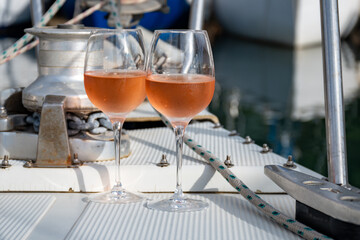 Party with rose wine on yacht boat anchored in port la Rague, Gulf of La Napoule, in Provence, two glasses of cold rose wine, French Riviera near Cannes, south of France