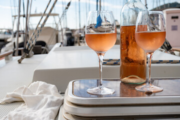 Party with rose wine on yacht boat anchored in port la Rague, Gulf of La Napoule, in Provence, two glasses of cold rose wine, French Riviera near Cannes, south of France