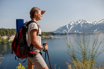 A Hiker Enjoying a Scenic View by the Beautiful Lake Surrounded by Majestic Mountains