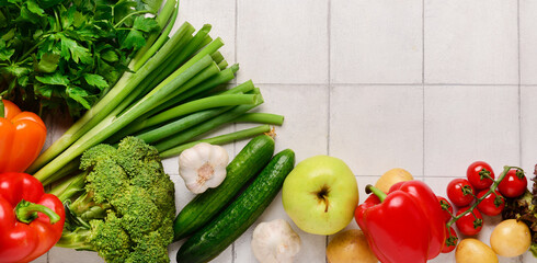 Wall Mural - Fresh vegetables on light tile background with space for text