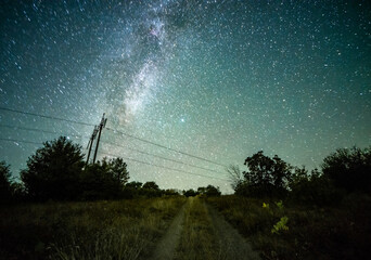 Wall Mural - Space with galaxy . Milky way on the blue sky .Dark and cold night at summer . Trees on the backgound with stars . Power lines in the night , powerstation and galaxy