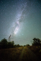 Wall Mural - Space with galaxy . Milky way on the blue sky .Dark and cold night at summer . Trees on the backgound with stars . Power lines in the night , powerstation and galaxy