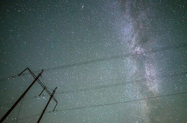 Wall Mural - Space with galaxy . Milky way on the blue sky .Dark and cold night at summer . Trees on the backgound with stars . Power lines in the night , powerstation and galaxy