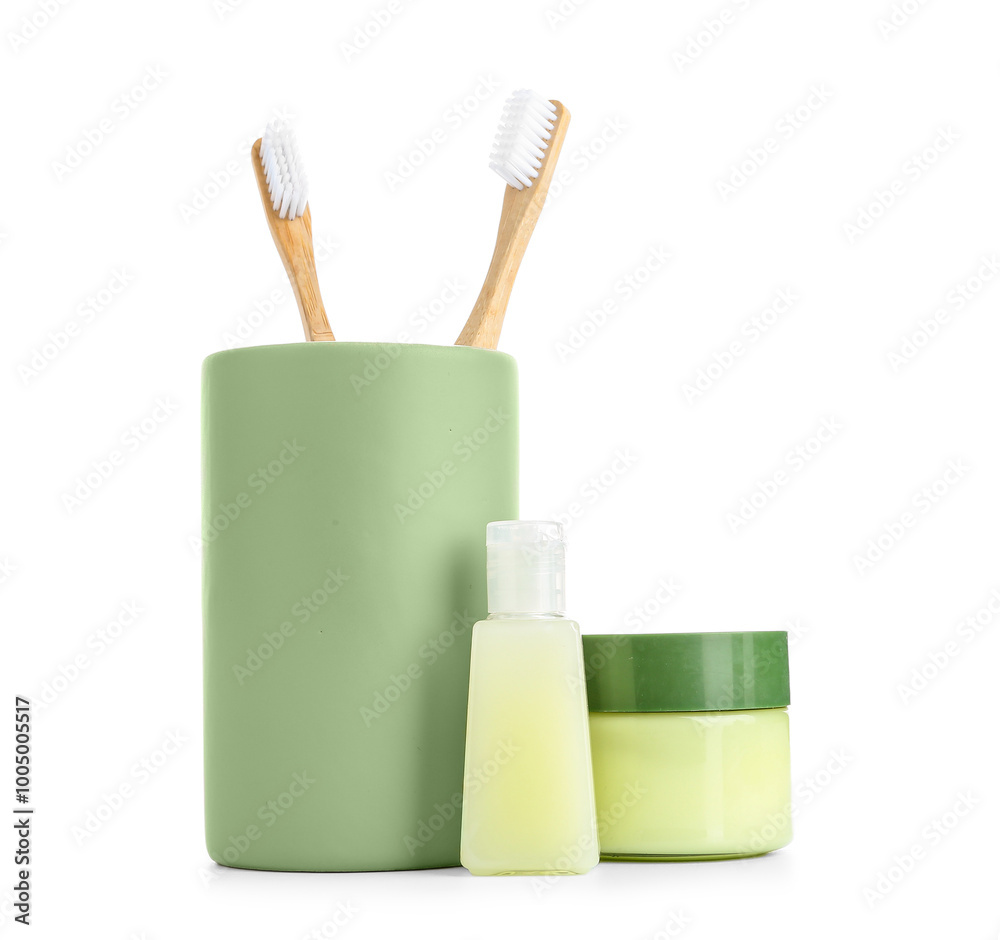 Toothbrush with jars of cream on white background