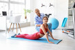 © Pixel-Shot - Young woman training with female physiotherapist on mat in rehabilitation center