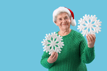 Sticker - Senior woman in Santa hat with snowflakes on blue background