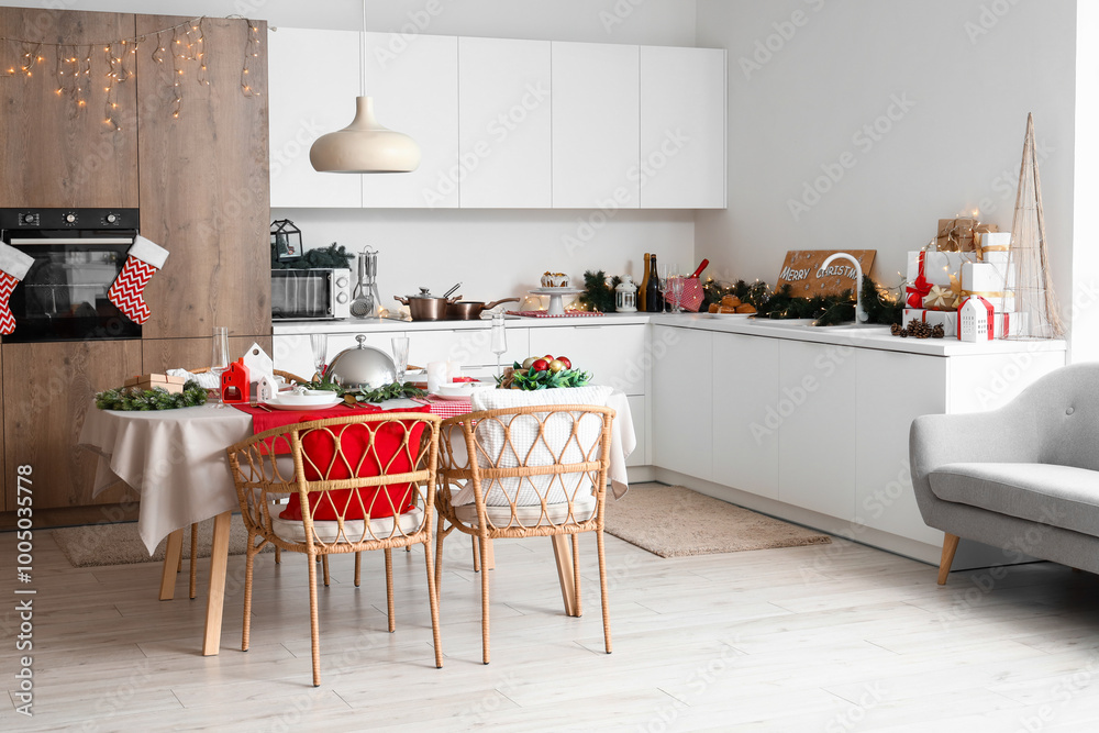 Interior of light kitchen with Christmas decorations and served table