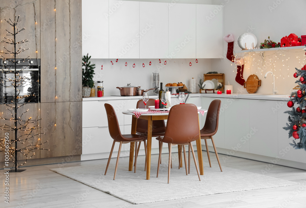 Interior of modern kitchen with festive table setting, Christmas tree and decor
