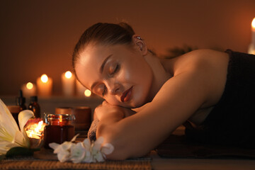 Poster - Beautiful young woman relaxing in dark spa salon, closeup