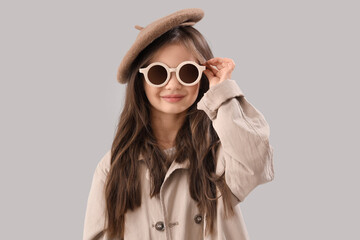 Wall Mural - Little girl in sunglasses on light background