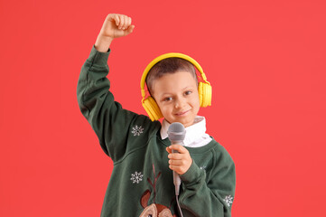 Poster - Cute little boy in headphones with microphone on red background