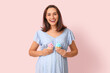 © Pixel-Shot - Beautiful happy pregnant woman with delicious cupcakes on pink background. Gender reveal party concept