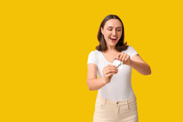 Sticker - Beautiful young woman with open condom on yellow background. Safe sex concept