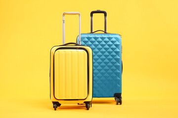 Sticker - Two different bright suitcases on yellow background