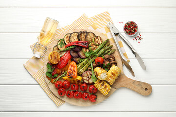 Delicious grilled vegetables served on white wooden table, flat lay