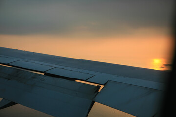 View of the airplane wing against the sunset during flight