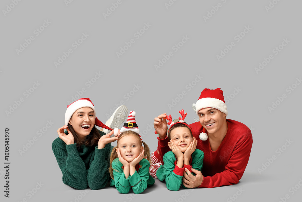 Happy family in Christmas clothes on grey background
