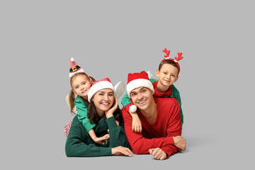 Wall Mural - Happy family in Christmas clothes on grey background