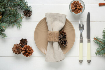 Wall Mural - Beautiful table setting with pine cones and Christmas tree branches on white wooden background