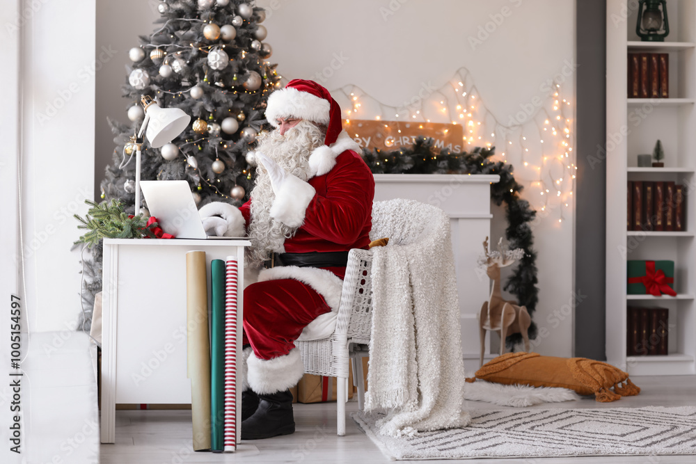 Santa Claus using laptop at home on Christmas eve