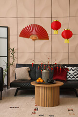 Canvas Print - Interior of modern living room with black sofa and traditional Chinese decorations. Chinese New Year celebration