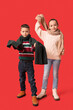 © Pixel-Shot - Cute little happy children in warm winter clothes on red background