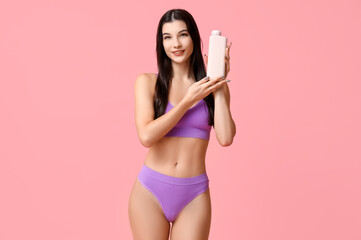 Poster - Beautiful young woman with bottle of cosmetic product on pink background