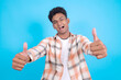 © Queenmoonlite Studio - Happy Young Asian Man in Casual Clothes Giving Thumbs Up Isolated on Blue Background