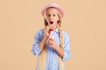 Wall Mural - Shocked teenager girl with bottle of tasty lemonade on beige background