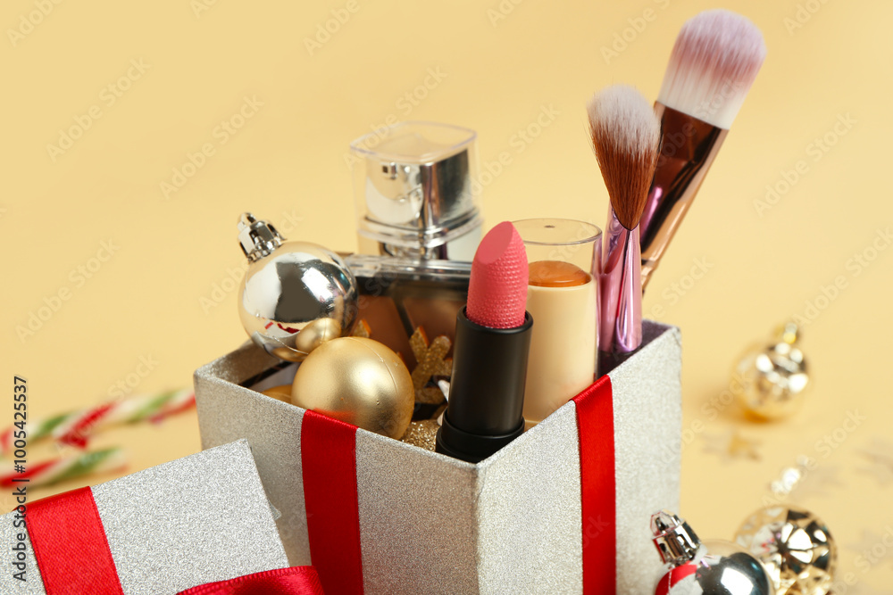 Christmas gift box with decorative cosmetics on beige background