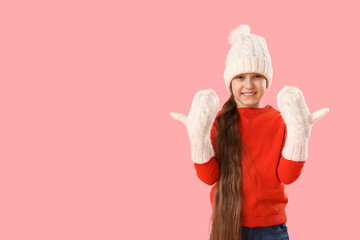 Poster - Cute happy little girl in warm Christmas clothes on pink background