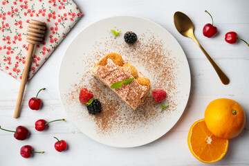 Italian tiramisu with red berry cream. Top view table with  decorations.