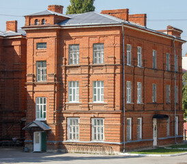 A large brick building with a green roof and a black awning