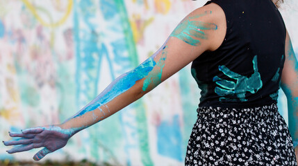 A woman with blue paint on her arm and hands