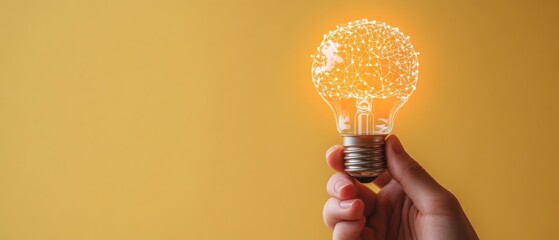 Poster - A hand delicately holds a glowing light bulb that emits a warm light, set against a vibrant yellow wall, symbolizing inspiration and bright ideas