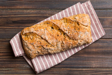 Wall Mural - Fresh loaves of bread with wheat and gluten on a colored table. bread on napkin on rustic background, fresh bread top view