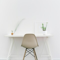 Poster - Success in minimalism: empty chair and desk with a small plant.