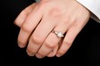 © Siripong - A close-up of a hand wearing a diamond ring, symbolizing love, commitment, and celebration of special moments.