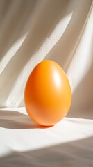 Poster - Orange egg on white cloth with soft shadows, minimalistic art concept