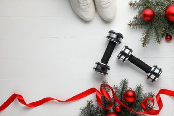 Poster - Dumbbells, sneakers, fir tree branches and Christmas baubles on white table, flat lay. Space for text