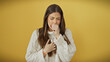 © Krakenimages.com - Hispanic woman coughing isolated over yellow background wearing white sweater.