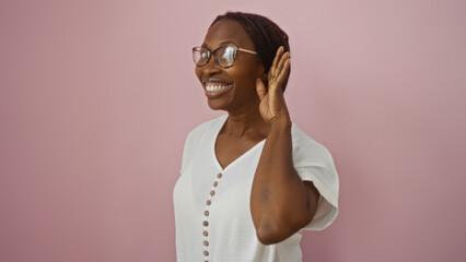 Sticker - African american woman smiling and holding hand to ear over an isolated pink background.