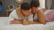 © Krakenimages.com - Men embracing on a bed in a cozy bedroom, showcasing love and togetherness.