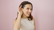 © Krakenimages.com - A smiling young woman makes a listening gesture against a pink background, evoking a sense of approachability and positivity.